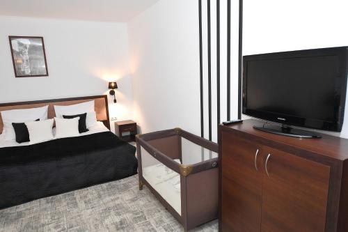 a bedroom with a flat screen tv on a dresser at Hotel Focus Centrum Konferencyjne in Lublin