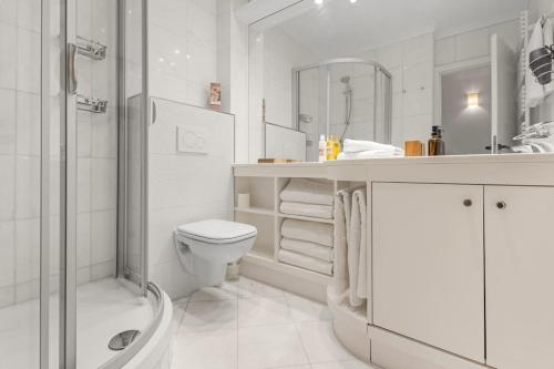 une salle de bain blanche avec toilettes et douche dans l'établissement Extraordinaire avec terrasse, à Cannes