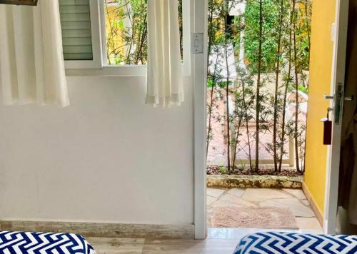 an open door with a view of a yard at Canto das Laranjeiras MOA in Guarujá