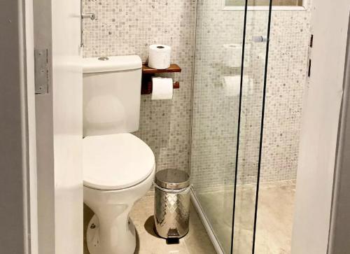 a bathroom with a toilet and a glass shower at Canto das Laranjeiras MOA in Guarujá