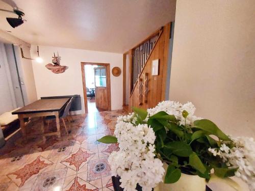 a living room with a table and a vase of flowers at Chambres d'hôtes - la Puysæ in Saint-Sauveur-en-Puisaye