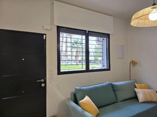 a living room with a blue couch and a window at San Basilio in Murcia