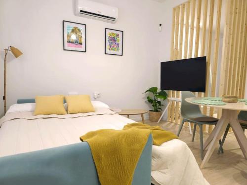 a bedroom with a bed and a table with a tv at San Basilio in Murcia