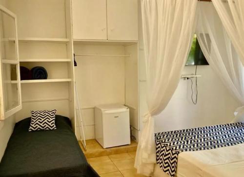 a small bedroom with a bed and a window at Canto das Laranjeiras MOA in Guarujá