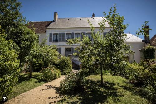 an old white house with trees in front of it at Chambres d'hôtes - la Puysæ in Saint-Sauveur-en-Puisaye