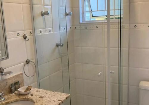 a bathroom with a shower with a glass door at Canto das Laranjeiras MOA in Guarujá
