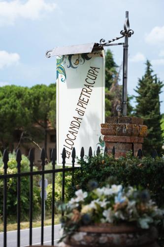 a sign in a cemetery with a cross and flowers at Locanda di Pietracupa in Tavarnelle in Val di Pesa