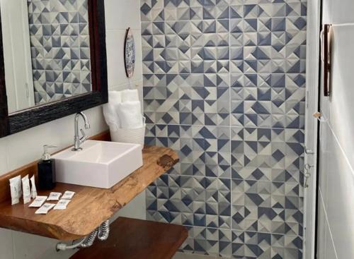 a bathroom with a white sink and a shower at Canto das Laranjeiras MOA in Guarujá