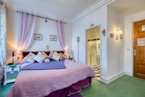 a bedroom with a bed with a purple bedspread at Les Cygnes in Évian-les-Bains