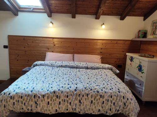 a bedroom with a large bed with a wooden headboard at "La casetta" indipendente, con ampio spazio verde in Fontechiari