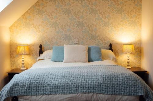 a bedroom with a large bed with two lamps at Granary Cottage at Scolton Cottages - Indoor pool in HAW