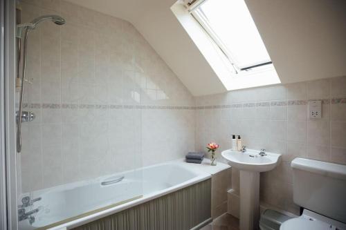 a bathroom with a bath tub and a sink at Granary Cottage at Scolton Cottages - Indoor pool in HAW