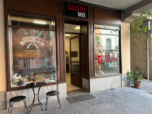 a store front with two chairs and a table in front at Affordable 3 roms appartment with special price summer 2025 in Dogliani