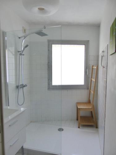 La salle de bains est pourvue d'une douche, d'une fenêtre et d'une chaise. dans l'établissement Chézine, T2 au calme avec balcon, 2pers et parking, à Nantes