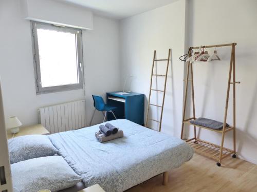 une chambre avec un lit avec une couverture bleue dans l'établissement Chézine, T2 au calme avec balcon, 2pers et parking, à Nantes