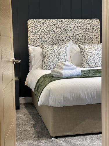 a bedroom with a bed with towels on it at Hollicarrs - White Rose Lodge in Riccall