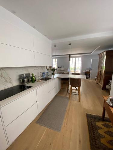 une cuisine avec des armoires blanches et un plancher en bois dans l'établissement Saint-Jean de Luz, bel appartement 3 pièces - 4 couchages, à Sainte-Barbe