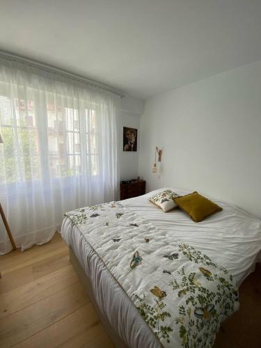 - une chambre avec un lit doté d'une couette blanche et d'une fenêtre dans l'établissement Saint-Jean de Luz, bel appartement 3 pièces - 4 couchages, à Sainte-Barbe