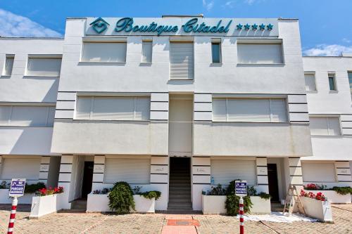 ein weißes Gebäude mit einem Schild darauf in der Unterkunft Apartamente Aparthotel Ella Boutik Cytadell in Eforie Sud