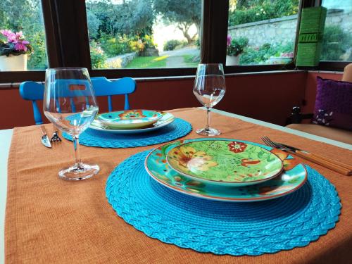 a table with two plates and wine glasses on it at "La casetta" indipendente, con ampio spazio verde in Fontechiari