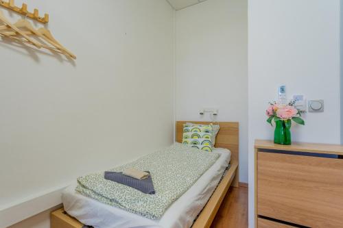 a small bedroom with a bed and a vase of flowers at Grassalkovich Residence in Budapest