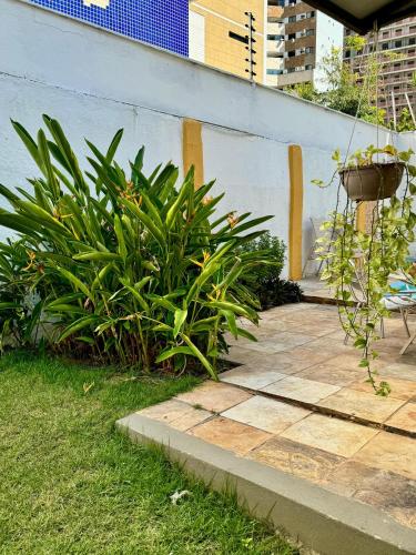a patio with plants next to a wall at Albergaria Hostel in Fortaleza