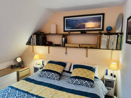 - une chambre avec un lit et une télévision murale dans l'établissement Agréable maison, jardin clos, 200m plage, à La Trinité-sur-Mer