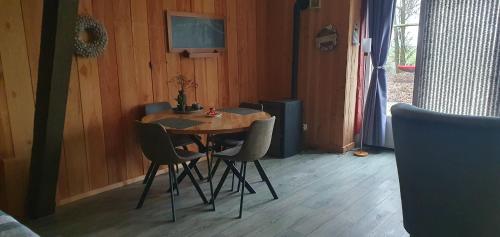 a small table and chairs in a room with wooden walls at De Groote Medwert in Holwerd