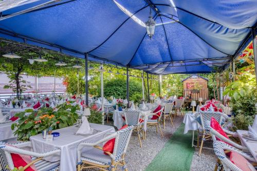 a group of tables and chairs under a blue umbrella at Les Cygnes in Évian-les-Bains