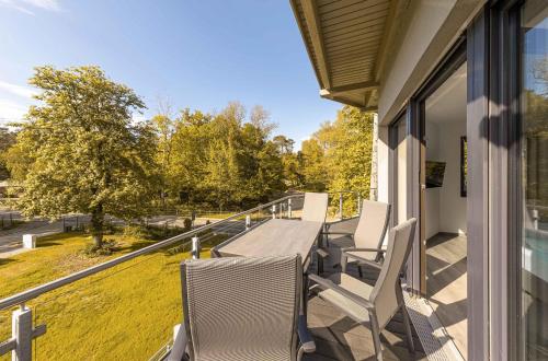 a porch with chairs and a table on a balcony at Shanti-Suite mit Dachterrasse, Kamin & Sauna am Krakower See in Krakow am See