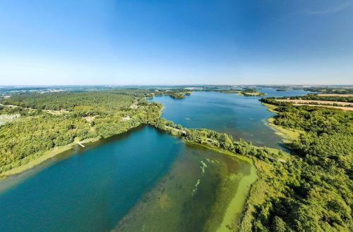 an aerial view of a river with trees and water at Bewusstsein - Modernes Apartment mit Terrasse, Walk-In-Dusche & Wellnesszugang in Krakow am See