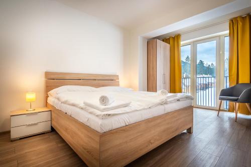 a bedroom with a bed and a desk and a window at Apartmánový dom Štiavnica in Liptovský Ján