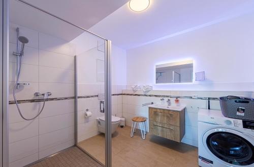 a bathroom with a washing machine and a washer at Sonnengruß - Stilvolles Apartment mit Balkon, Kamin & Wellness-Flair am Krakower See in Krakow am See