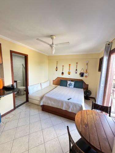 a bedroom with a bed and a wooden table at Flet pé na areia dos anjos in Arraial do Cabo