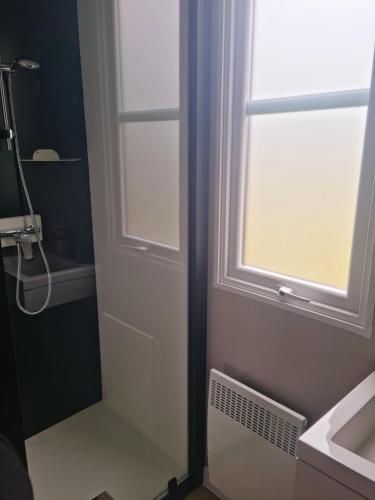 La salle de bains est pourvue d'une porte blanche et d'une fenêtre. dans l'établissement MOBILHOME 8p 3 CH 2 SDB SAINT JEAN DE MONTS, à Saint-Jean-de-Monts