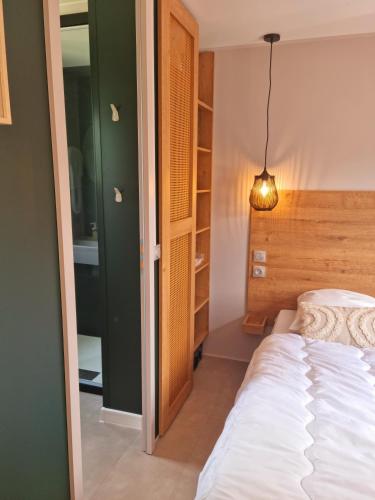 une chambre avec un lit blanc et une lampe dans l'établissement MOBILHOME 8p 3 CH 2 SDB SAINT JEAN DE MONTS, à Saint-Jean-de-Monts