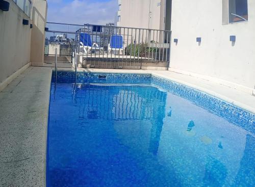 a swimming pool with blue water in front of a building at Hotel Nontue Abasto Buenos Aires in Buenos Aires
