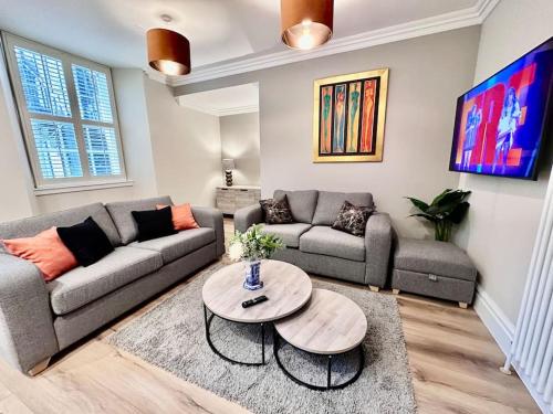 a living room with a couch and a table at Spectacular 2 bed, 2 bath in Edinburgh City Centre in Edinburgh