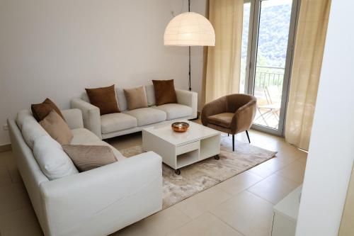 a living room with a white couch and a table at Morinj Lavender Bay apartment E5 in Donji Morinj