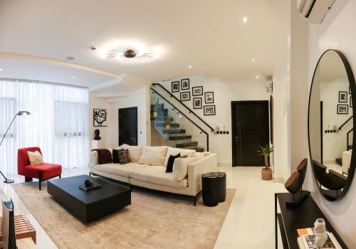 a living room with a white couch and a red chair at George Residence Cooper Road, Ikoyi in Lagos
