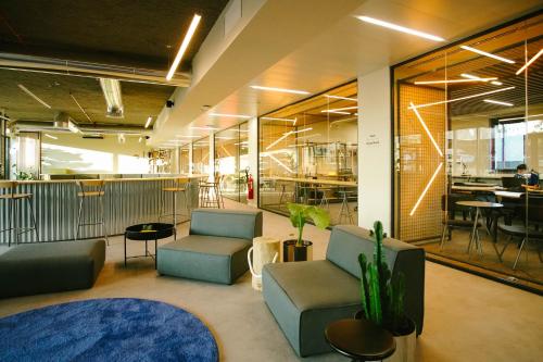 a lobby with couches and chairs in an office at Micampus Braga Student Residence in Braga