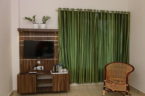 a room with a television and a green curtain at Sky Elanza in Munnar