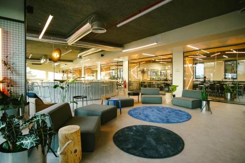 a large lobby with couches and tables and plants at Micampus Braga Student Residence in Braga
