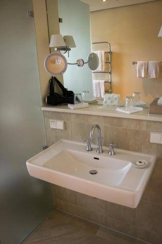 a bathroom with a sink and a mirror at Rheinhotel Schulz in Unkel