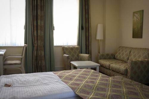 a hotel room with a bed and a couch at Rheinhotel Schulz in Unkel