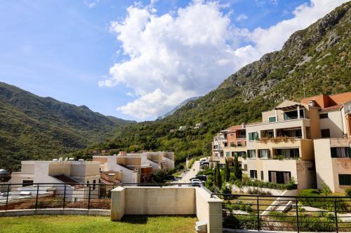 a view of a town with mountains in the background at Morinj Lavender Bay Apartment E3 in Donji Morinj