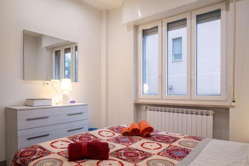 a bedroom with a bed with a dresser and windows at Appartamento Lussuoso in Lodi