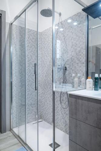 a bathroom with a glass shower and a sink at Appartamento Lussuoso in Lodi