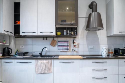 a kitchen with white cabinets and a sink at Appartamento Lussuoso in Lodi