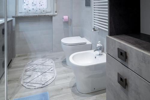 a white bathroom with a toilet and a sink at Appartamento Lussuoso in Lodi